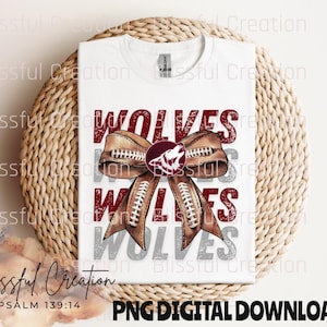 Peut inclure: T-shirt blanc avec un motif graphique rouge, blanc et marron représentant le mot "WOLVES" répété trois fois. Le motif comprend un nœud en forme de ballon de football avec une tête de loup au centre. Le texte "PSALM 139:14" est imprimé sous le motif.
