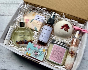 May include: A gift box filled with bath and body products, including a bath bomb, bath salts, body oil, soap, room mist, and a candle. The candle has a quote about friendship: "A friend is someone who knows all about you and still loves you."