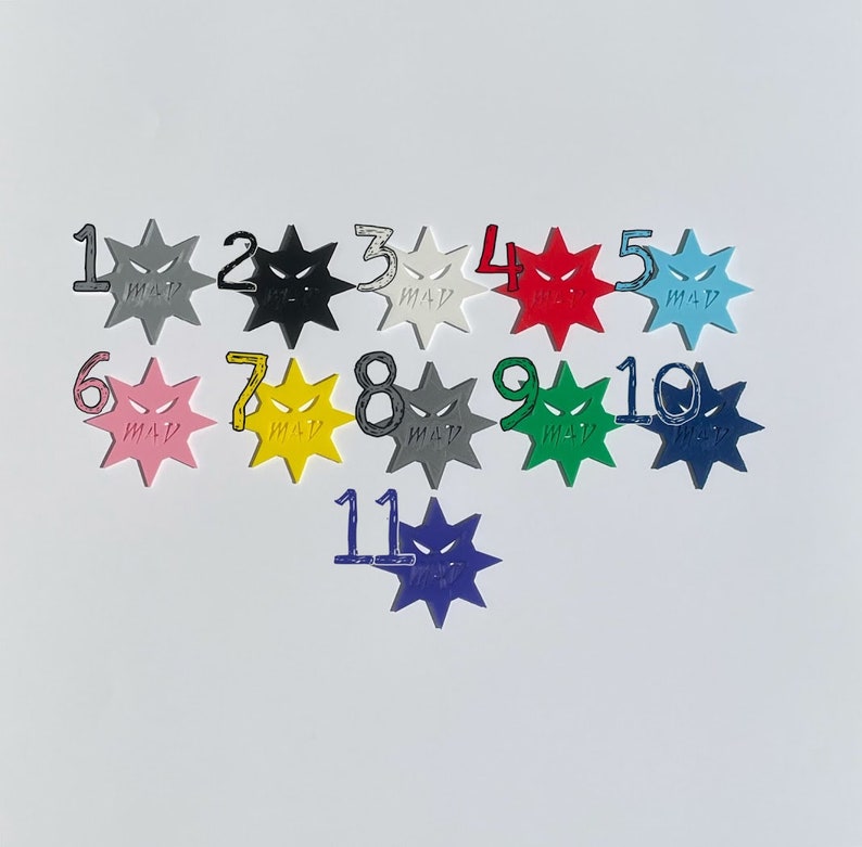 May include: Eleven colorful star-shaped tokens with a black and white angry face design. Each token is numbered 1 through 11.