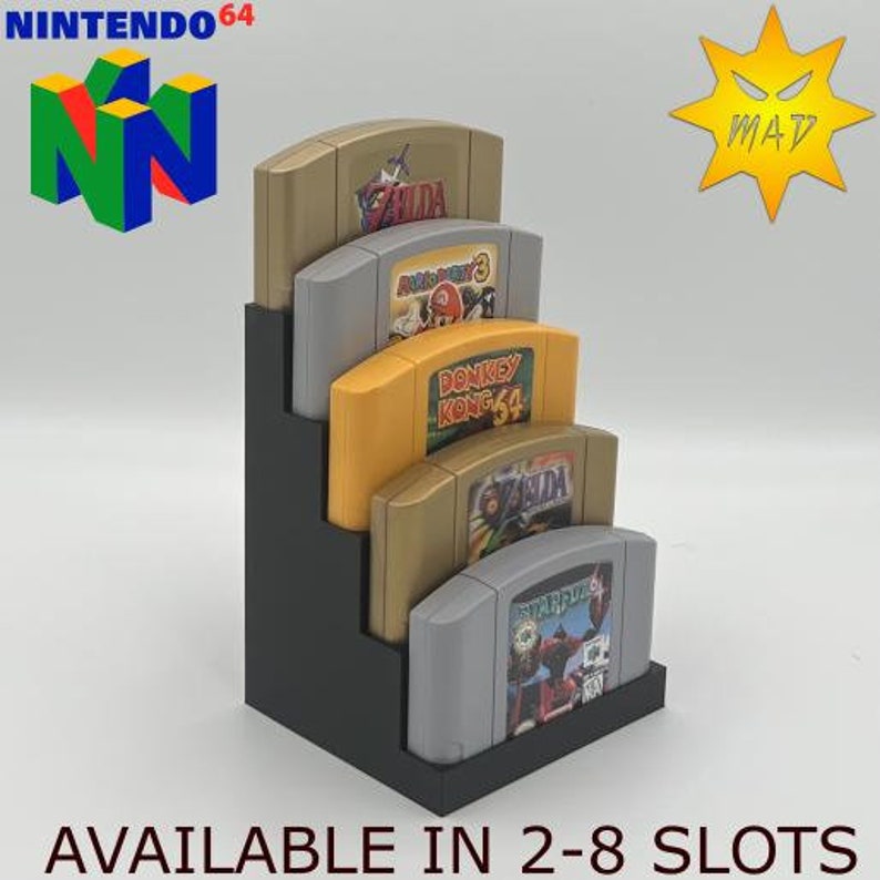 May include: A black stand with five slots for Nintendo 64 game cartridges. The stand is filled with five different game cartridges, including Zelda, Donkey Kong 64, and Star Fox 64. The stand is available in sizes from 2 to 8 slots.
