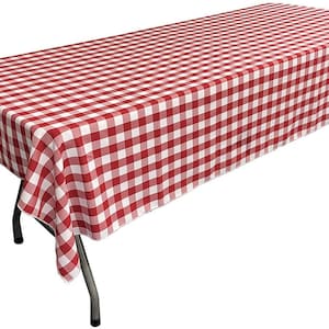 May include: A red and white checkered tablecloth draped over a rectangular folding table. The tablecloth has a classic gingham pattern, and the table has black metal legs. The table is suitable for outdoor events.