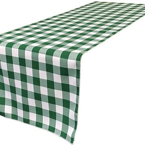 May include: Green and white checkered table runner. The runner is made of a soft, woven fabric and has a subtle sheen. It is perfect for adding a touch of elegance to any table setting.