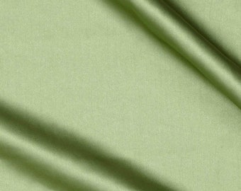 May include: A close-up shot of a light green fabric with a satin finish. The fabric is draped, creating soft folds and shadows. The color is a muted, pastel green, and the material appears smooth and luxurious.