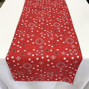 May include: Red table runner with a white bandana print.