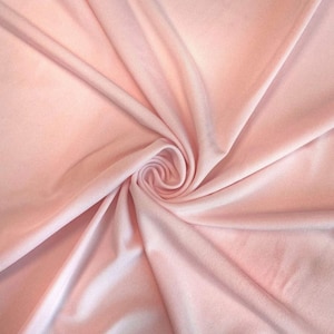 May include: A close-up of a soft, pink fabric with a smooth texture. The fabric is folded and draped, creating a gentle, flowing effect.
