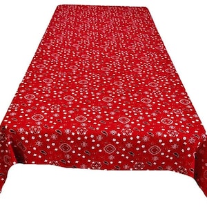 May include: A red rectangular tablecloth with a white paisley and geometric pattern. The tablecloth is made of a soft fabric and is suitable for a dining table or a picnic.