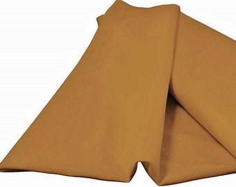 May include: A folded piece of fabric in a warm, golden-brown color. The fabric is smooth and appears to be a medium weight, with soft folds and creases. The background is plain white, highlighting the fabric's color and texture.