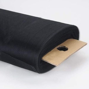 May include: A roll of black tulle fabric, a sheer, lightweight material often used for crafts, decorations, and clothing. The fabric is rolled up and secured with a brown cardboard tag.