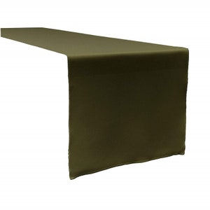 May include: Olive green table runner. The runner is made of a solid color fabric and is draped over a surface. The fabric has a slight sheen. The runner is a rectangular shape and is designed to be placed on a table.
