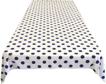 May include: White rectangular tablecloth with a repeating pattern of navy blue polka dots. The tablecloth is made of a smooth fabric and is suitable for a dining table or event.