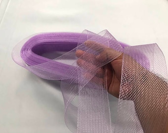 May include: A roll of sheer, lavender ribbon with a mesh-like texture. The ribbon is held in a hand, showcasing its delicate weave and color. Ideal for crafts, gift wrapping, or decorative purposes.