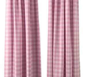 May include: Two pink and white checkered curtains hanging from a dark rod. The curtains are made of a soft fabric and are gathered at the top. The checkered pattern is a classic design.