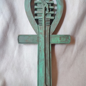 Può includere: Un Ankh in legno verde, un antico simbolo egizio della vita, con intagli intricati e una finitura usurata.