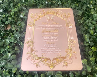 May include: A pink and gold invitation card with ornate gold filigree and a butterfly design. The text reads "Mary & Maria" and "Esmeralda" with details about a quinceañera celebration.