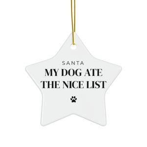 May include: A white star-shaped ceramic ornament hanging from a gold string. The text reads SANTA MY DOG ATE THE NICE LIST in black capital letters, with a small black paw print icon centered below the text on the smooth, glossy surface.