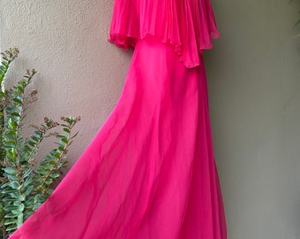May include: A hot pink maxi dress with a pleated cape-style top and a flowing skirt.