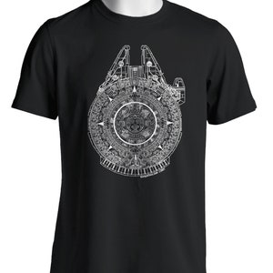 Puede incluir: Una camiseta negra con un gráfico blanco del Millennium Falcon superpuesto al calendario azteca. El gráfico es detallado e intrincado, con la silueta de la nave espacial claramente visible.