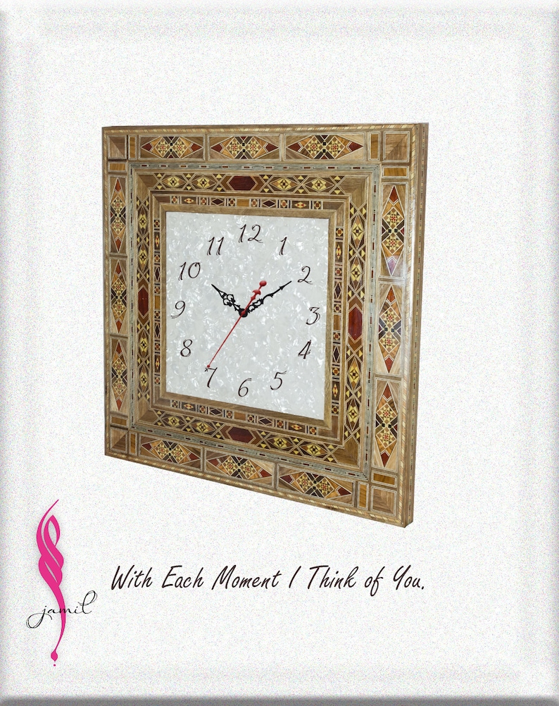May include: A square clock with a white face and black hands, surrounded by a decorative frame made of inlaid wood in shades of brown, red, and gold. The frame has a geometric pattern.