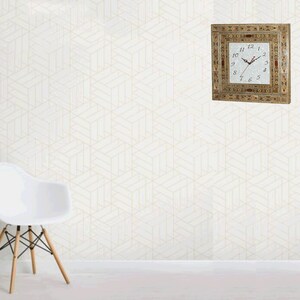 May include: A square clock with Roman numerals and a white face. The clock is framed in a decorative wood frame with inlaid designs in various colors. The clock is hanging on a white wall with a geometric pattern.