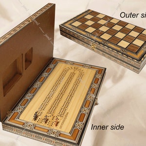 May include: A wooden game box with inlaid designs. The box opens to reveal a cribbage board with two sets of pegs. The top of the box features a checkerboard.