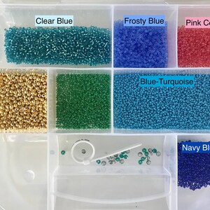 May include: A clear plastic storage box with 10 compartments filled with various colours of seed beads. The compartments are labelled with the bead colours: Clear Blue, Frosty Blue, Pink Coral, Blue-Turquoise, and Navy Blue.