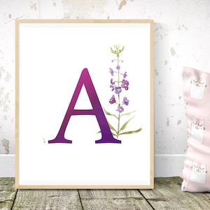 May include: A watercolor print featuring the letter A in a gradient of purple and pink, with a stylized purple flower illustration to the right of the letter.