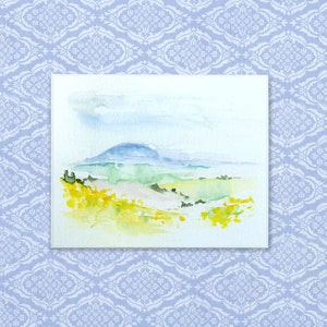 May include: Watercolor painting of a landscape with a blue mountain in the background and green hills in the foreground. The sky is a light blue with white clouds. The hills are covered in yellow wildflowers.