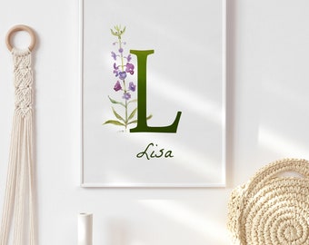 Può includere: Una stampa incorniciata bianca con una lettera L verde e fiori viola. Il nome Lisa è scritto sotto la lettera.