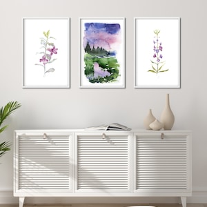 Pode incluir: Tr&ecirc;s pinturas em aquarela emolduradas de temas bot&acirc;nicos. A obra de arte inclui um arranjo floral roxo e verde, uma paisagem com um c&eacute;u roxo e azul e uma flor roxa e verde. As pinturas s&atilde;o exibidas acima de um arm&aacute;rio branco.