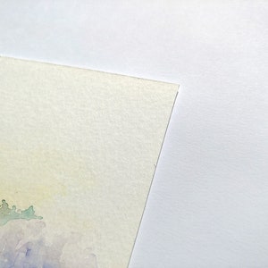 May include: A watercolor painting on textured paper with a light yellow background and a purple and green landscape in the bottom left corner.