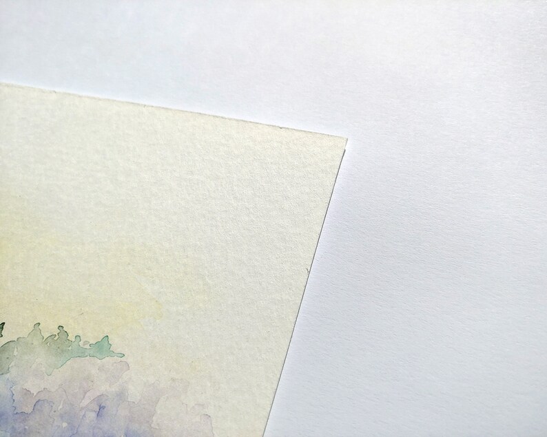 May include: A watercolor painting on textured paper with a light yellow background and a purple and green landscape in the bottom left corner.