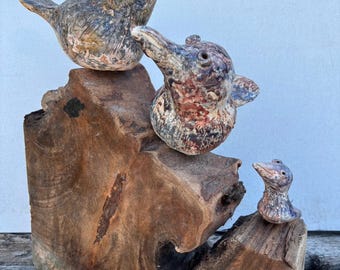 Unique ceramic bird family on old wood