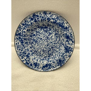 以下が含まれることがあります： 黒縁の青と白の斑点模様のエナメル製のディナー皿