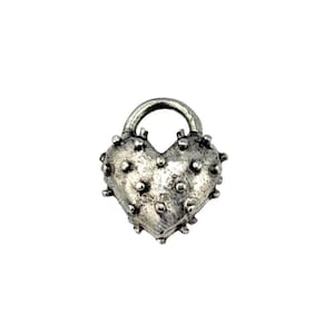 May include: A silver heart-shaped padlock with a textured surface and small, rounded protrusions. The padlock has a curved handle at the top, giving it a vintage appearance. The heart shape is the central design element, with a detailed finish.