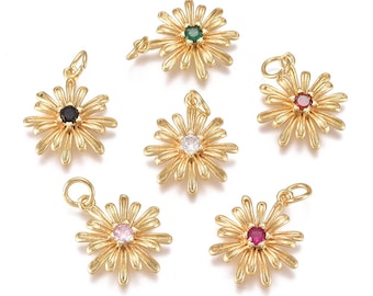 May include: Gold-coloured daisy flower charms with various coloured centre stones. The charms have a loop for attaching to jewellery. The centre stones are black, green, white, red, pink, and a darker red.
