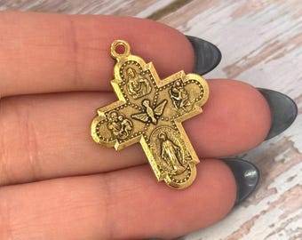 Könnte beinhalten: Ein goldfarbener Metallkreuz-Anhänger mit vier verschiedenen geprägten religiösen Figuren in den Armen und einem Taubenmotiv in der Mitte. Der untere Teil enthält ein kleines kreisförmiges Bild mit dem Text Regina Sine Labe Concepta.