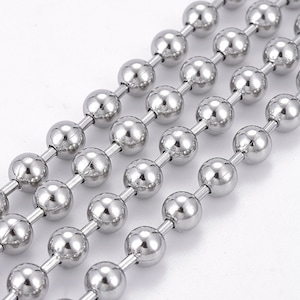 May include: A silver ball chain necklace with multiple strands of round beads. The chain is made of metal and has a polished finish.
