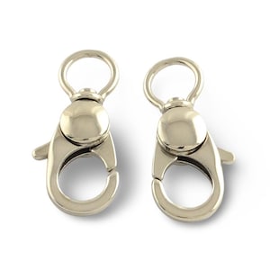 May include: Two silver-colored swivel clasps. Each clasp has a rounded top with a ring, a bulbous center, and a spring-loaded lever to open and close the clasp. The clasps are designed for attaching to bags, keychains, or other accessories.