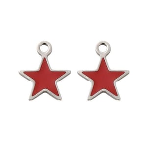 May include: Two star-shaped charms with a red enamel center and a silver-colored border. Each charm has a small loop at the top for attaching to jewelry or other crafts. The charms are set against a white background.