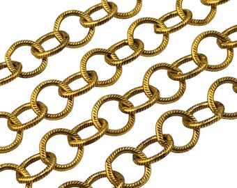 May include: A gold-toned metal chain featuring a series of interconnected circular links. Each individual link has a textured, twisted rope-like surface pattern, creating a repeating design across the length of the chain segments.