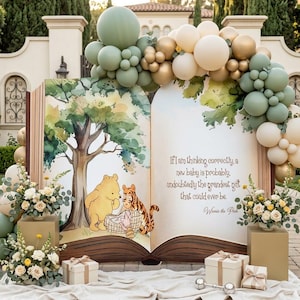 May include: A large open book display featuring Winnie the Pooh and Tigger illustrations, decorated with a sage green, cream, and gold balloon arch. The text reads: If I am thinking correctly, a new baby is probably, undoubtedly the grandest gift that could ever be.