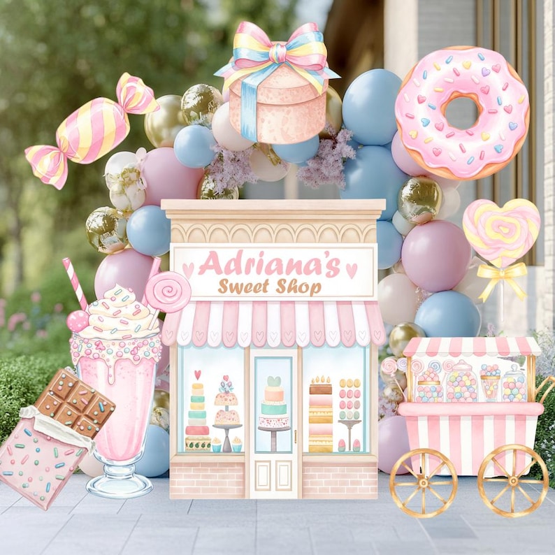 May include: A party decoration set featuring a central shop facade labeled Adriana's Sweet Shop, surrounded by balloons, a pink donut, a chocolate bar, a milkshake, a gift box, and a candy cart, all in pastel pink, blue, and gold colors.