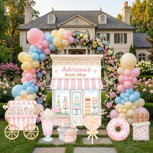 May include: A decorative sweet shop display featuring a pastel balloon arch, a candy cart, a milkshake, a gift box, a heart-shaped lollipop, a donut, and a chocolate bar. The central structure is labeled Adriana's Sweet Shop in pink text.