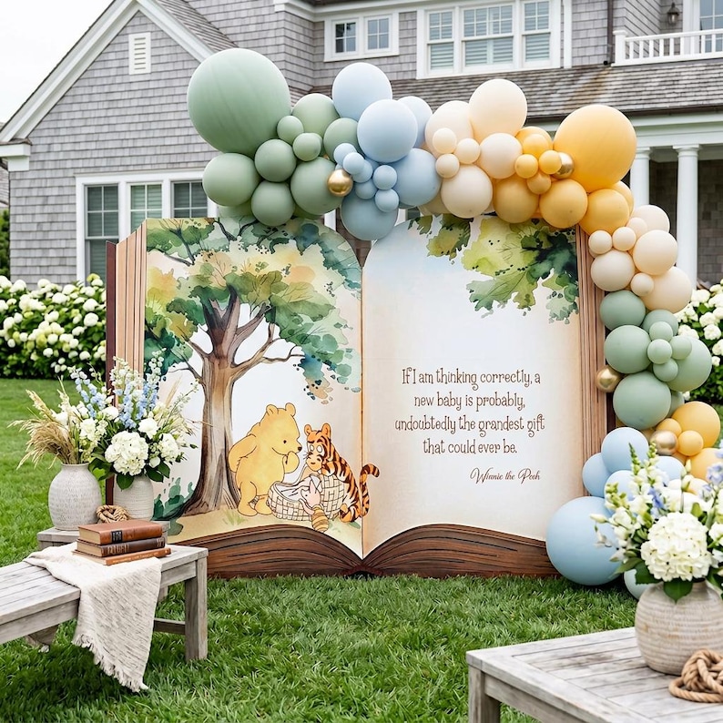 May include: A large open book prop featuring a watercolor illustration of Winnie the Pooh and Tigger, with the text: If I am thinking correctly, a new baby is probably, undoubtedly the grandest gift that could ever be. Winnie the Pooh. Balloon arch.