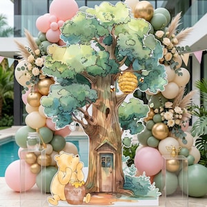 Puede incluir: Un recorte grande de un &aacute;rbol con una colmena y una puerta, que muestra a un oso amarillo sentado con un tarro de miel etiquetado como 'HUNNY'. La decoraci&oacute;n est&aacute; rodeada por un arco de globos en tonos rosa, verde salvia y dorado.