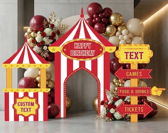 May include: A carnival-themed party display featuring a red and white striped tent arch with the text HAPPY BIRTHDAY, a smaller matching booth with CUSTOM TEXT, and a yellow signpost with arrows labeled YOUR CUSTOM TEXT, GAMES, FOOD & DRINKS, and TICKETS.