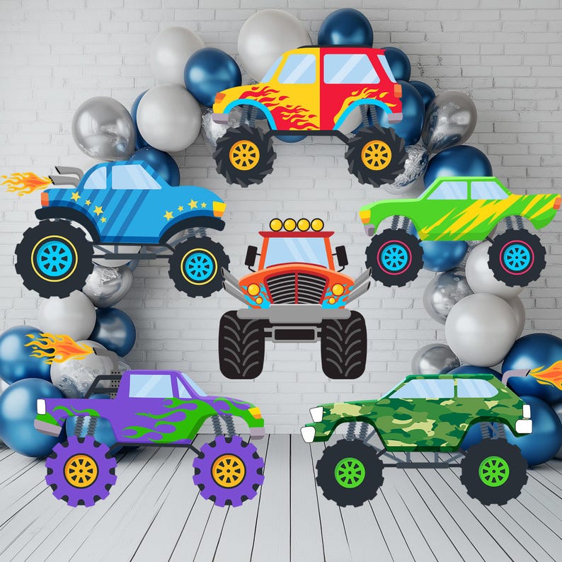 Op de afbeelding: Een verzameling kleurrijke monstertruck-uitsparingen, waaronder rode, gele, blauwe, groene en paarse ontwerpen. Elke truck heeft grote wielen en decoratieve vlammen of patronen. De trucks zijn gerangschikt met een achtergrond van zilveren, witte en blauwe ballonnen.