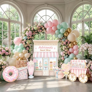 May include: A party decoration set featuring a central sign labeled Adriana's Sweet Shop, surrounded by pastel balloons and floral arches. Includes cutouts of a pink frosted donut, a chocolate bar, a milkshake, a gift box, and a candy cart.