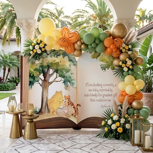 May include: A large open book backdrop featuring Winnie the Pooh and Tigger illustrations with the text, If I am thinking correctly, a new baby is probably, undoubtedly the grandest gift that could ever be. Decorated with yellow, orange, green, and gold balloons.
