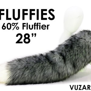 Może przedstawiać: Puszysty, szary i biały ogon z imitacji futra, o długości 71 cm. Ogon jest przymocowany do manekina, a na zdjęciu widoczny jest tekst "FLUFFIES 60% Fluffier 28".